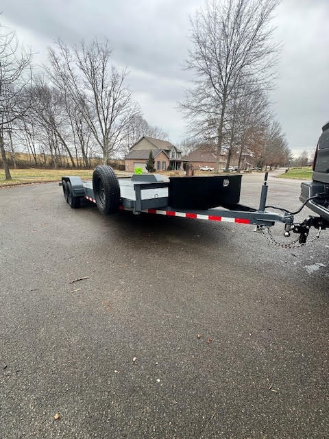 Flatbed car hauler trailer rental - front angle view showing loading ramps and steel deck