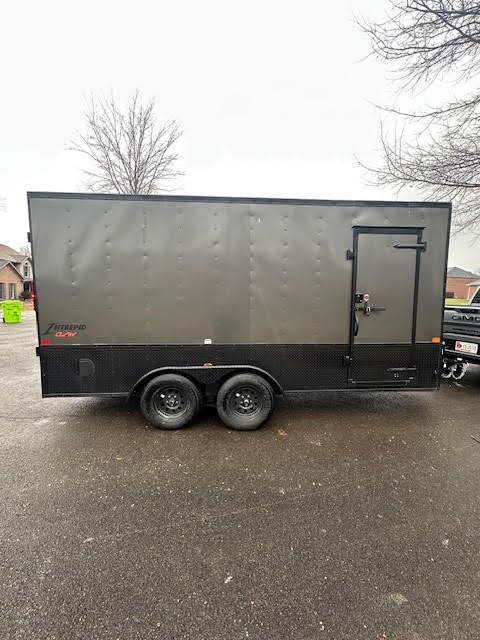 Enclosed cargo trailer rear angle - showing dual axles and ramp door