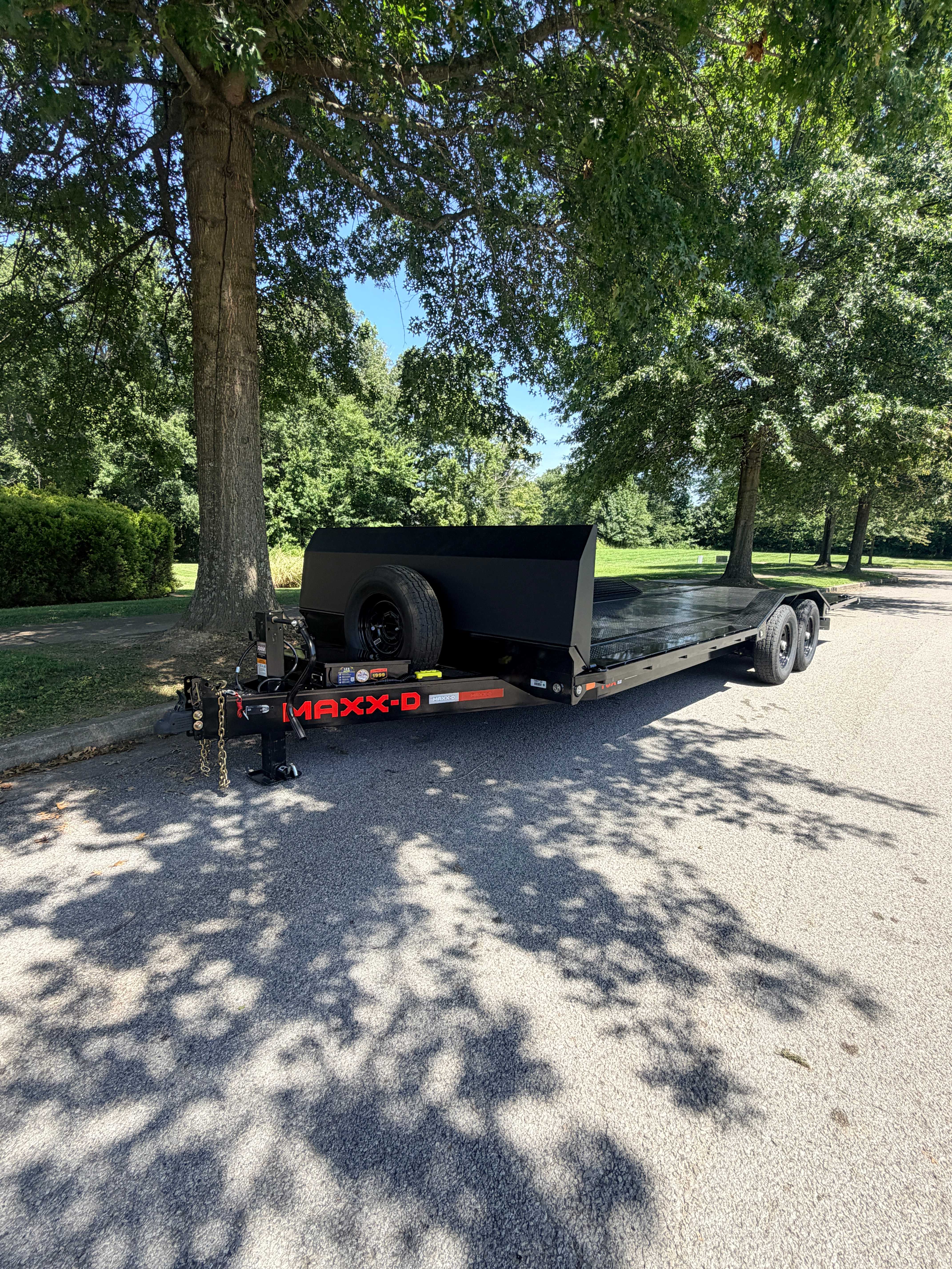 Maxx-D T6X 24ft tilt car hauler trailer - front angle showing tongue, spare tire and tandem axles