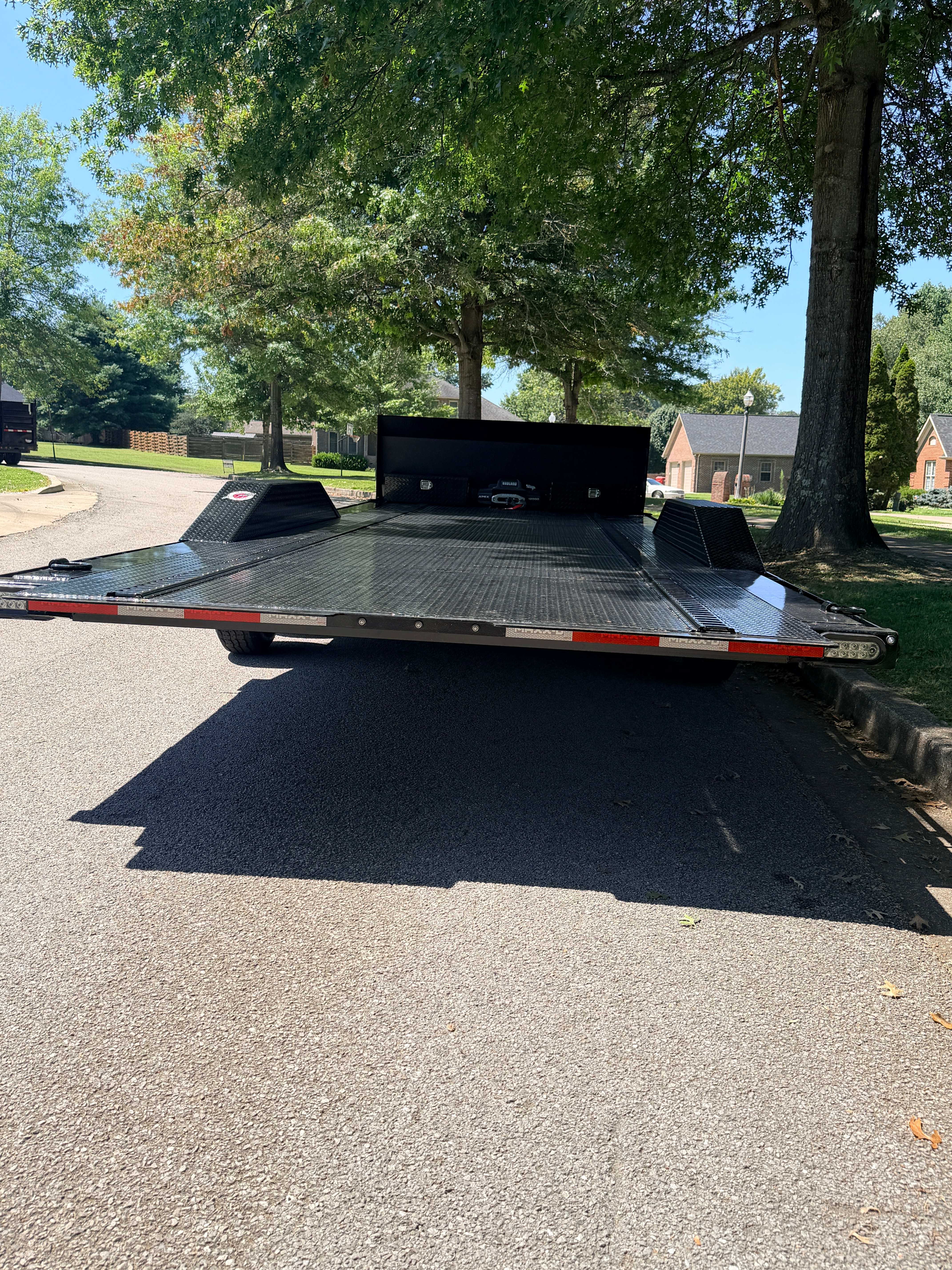 Car hauler tilt trailer rear view - full-width steel deck with drive-over fenders